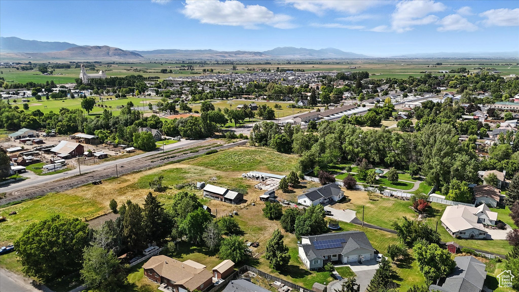 Aerial view of property and surrounding area with mountains and nearby suburban area