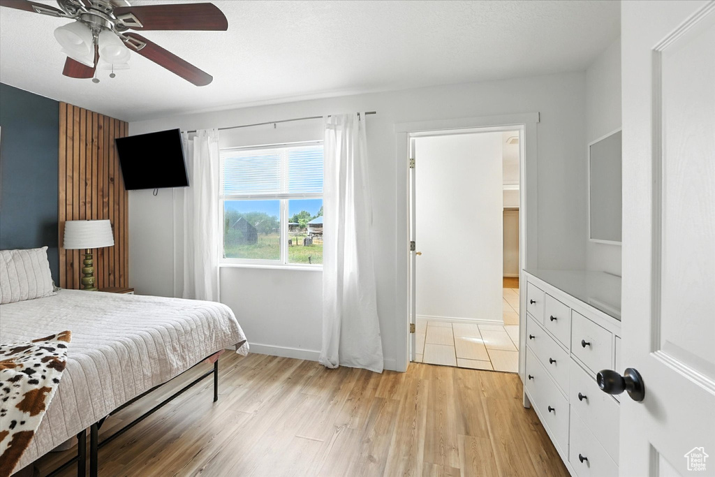 Bedroom with light wood-style floors and a ceiling fan