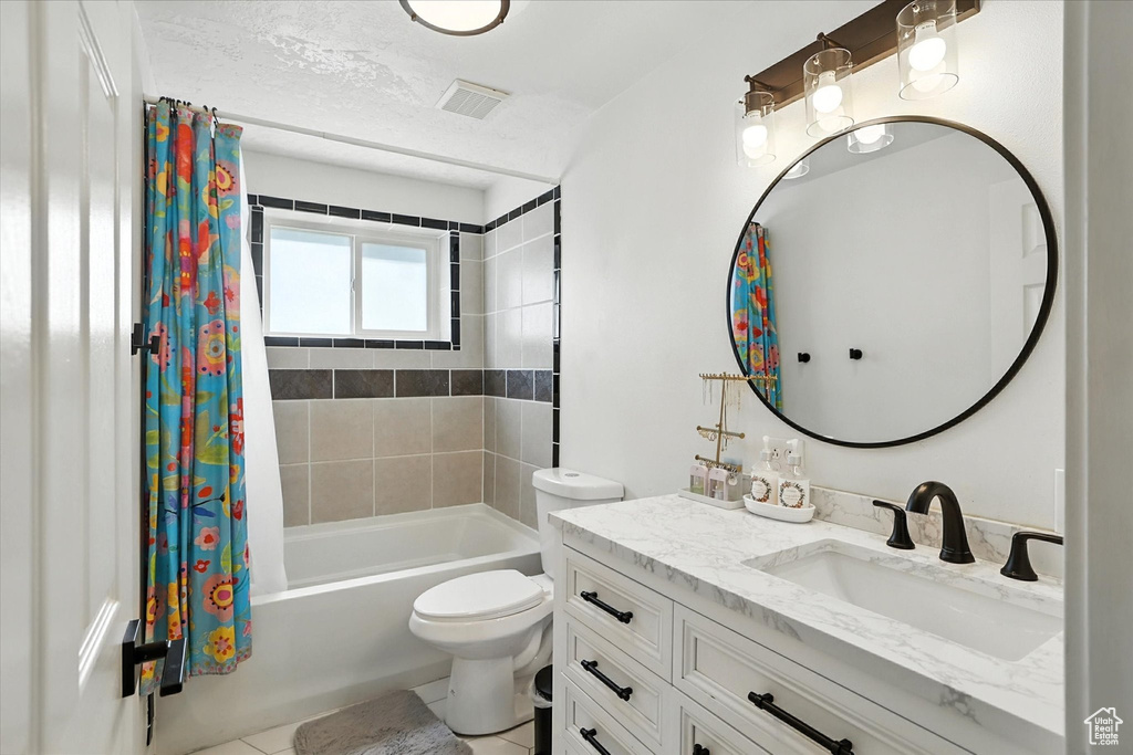 Bathroom featuring vanity, shower / bathtub combination with curtain, and tile patterned floors