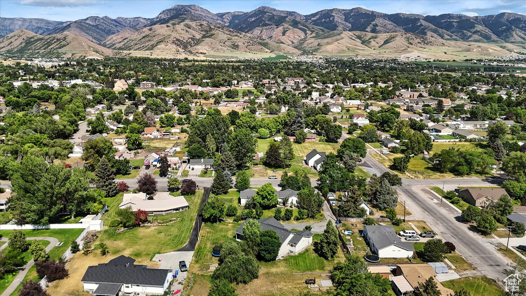 Aerial view of property and surrounding area featuring nearby suburban area and a mountain backdrop