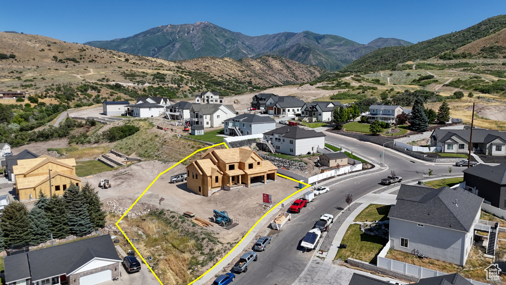 Aerial view of residential area with a mountain backdrop and property boundaries highlighted