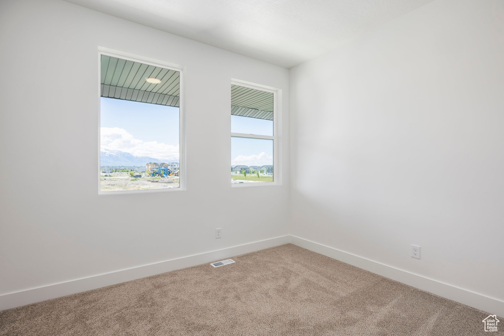 Empty room featuring carpet flooring and baseboards