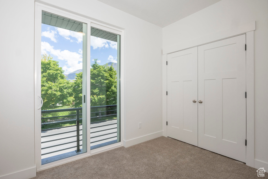 Unfurnished bedroom with carpet floors, multiple windows, and a closet
