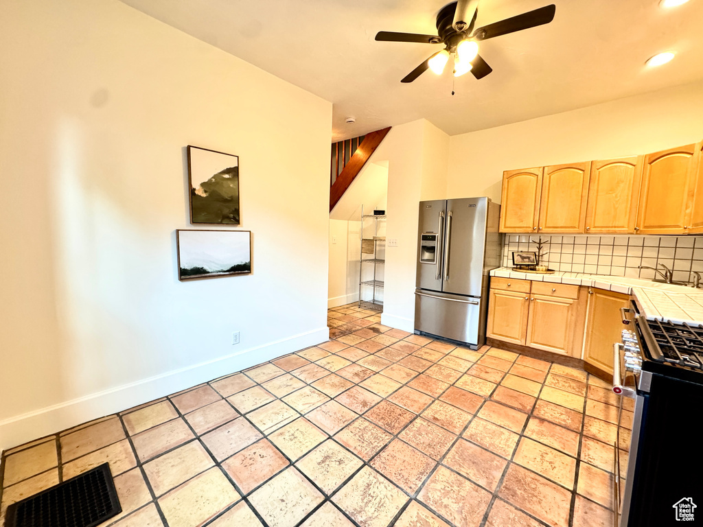 Kitchen featuring appliances with stainless steel finishes, tile counters, light brown cabinetry, a ceiling fan, and recessed lighting