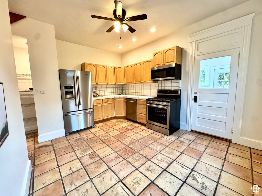 Kitchen featuring appliances with stainless steel finishes, light brown cabinets, tasteful backsplash, a ceiling fan, and recessed lighting