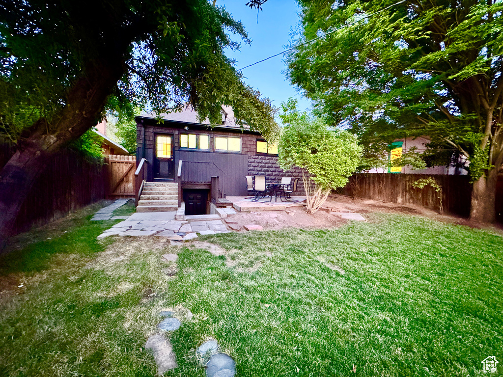 Rear view of property with a fenced backyard and a patio