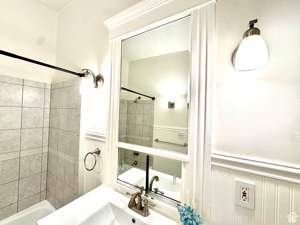Full bathroom featuring a wainscoted wall and a sink