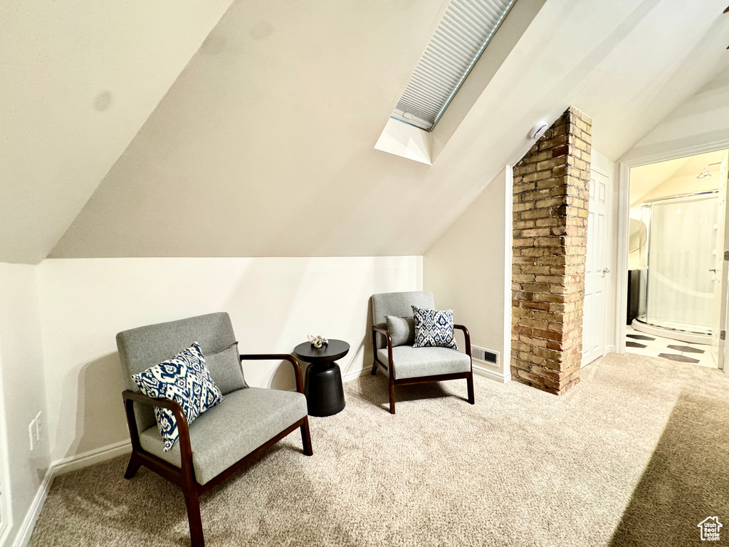 Sitting room featuring carpet floors, vaulted ceiling, and a skylight