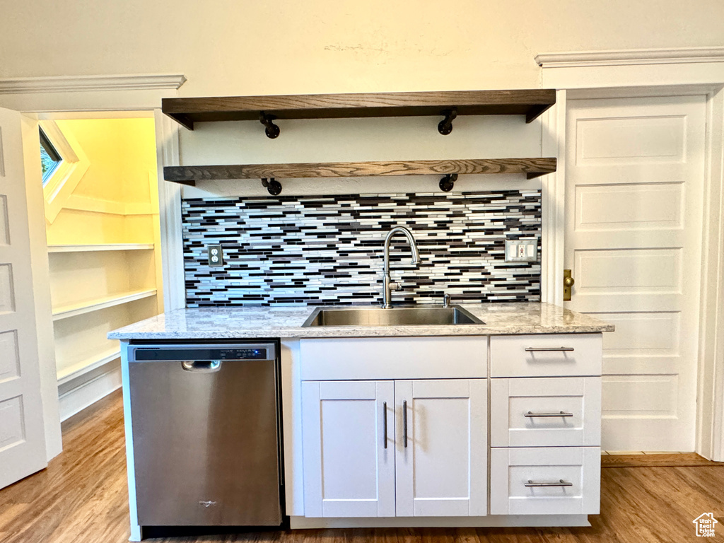 Kitchen featuring dishwasher, open shelves, light wood finished floors, and backsplash