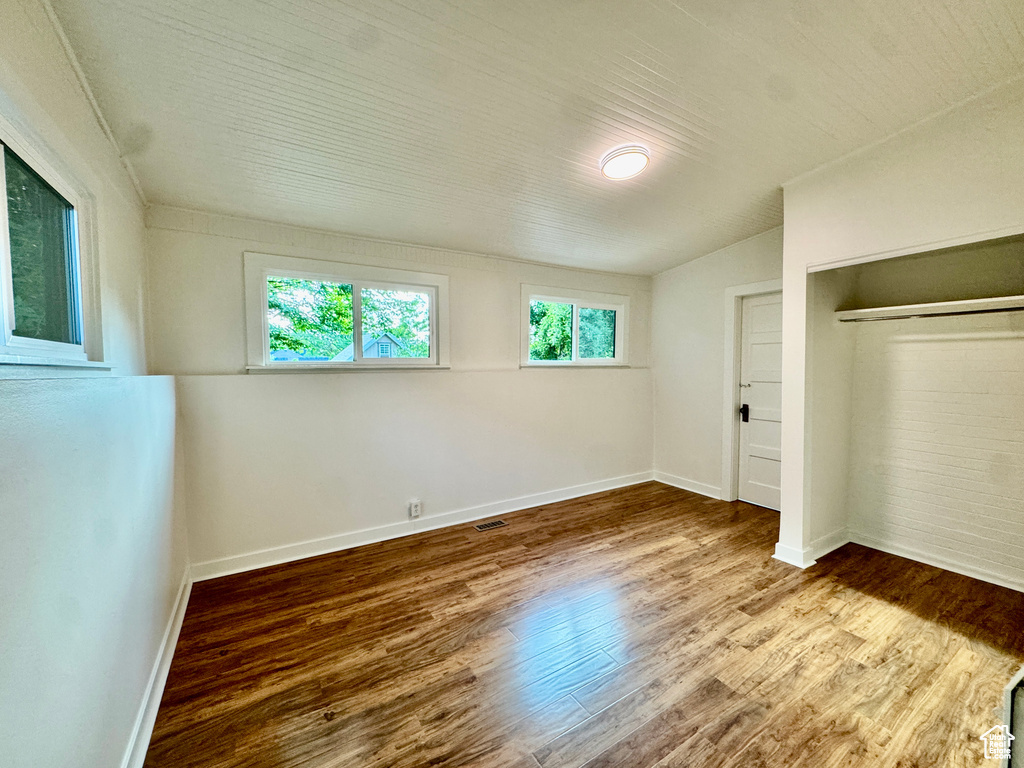 Unfurnished bedroom featuring wood finished floors and a closet