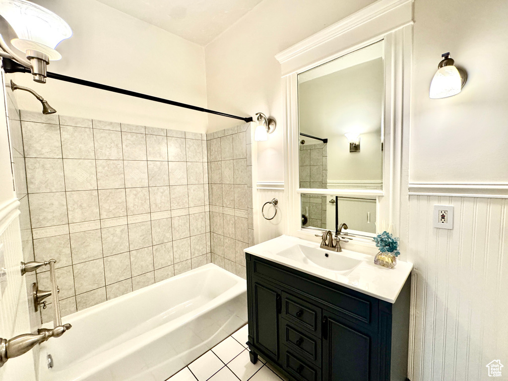 Full bath with a wainscoted wall, shower / washtub combination, vanity, and tile patterned flooring