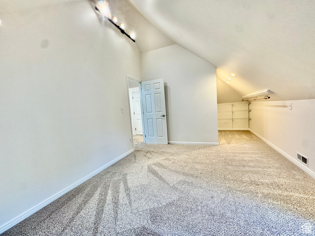 Additional living space featuring vaulted ceiling and carpet floors