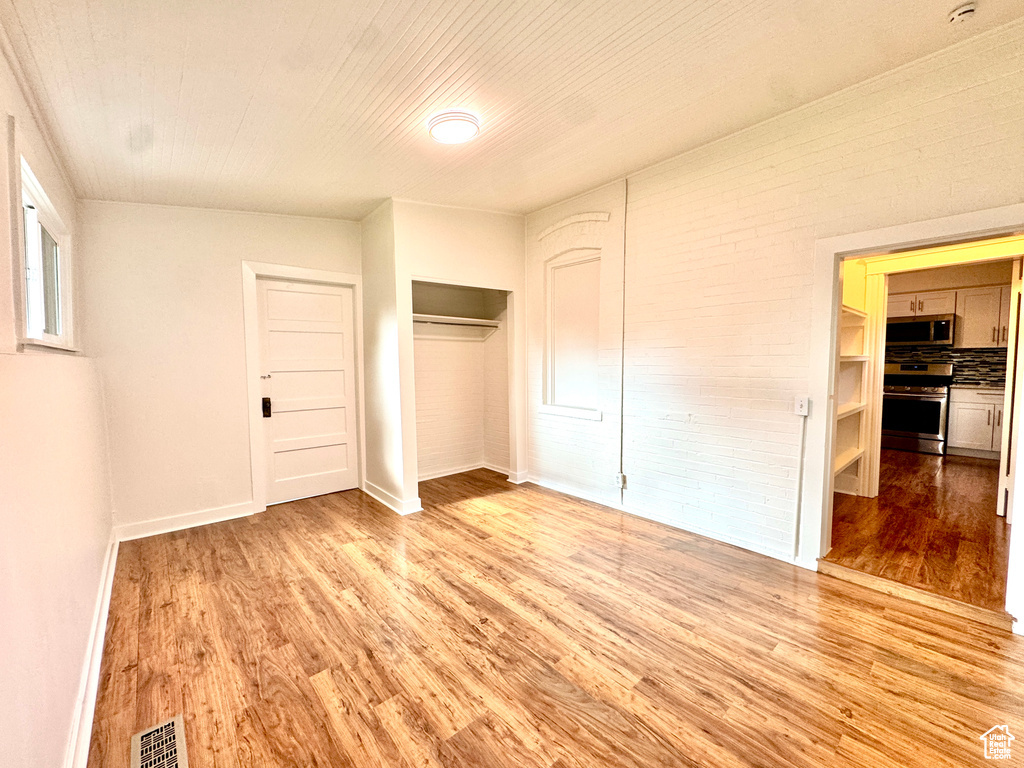 Unfurnished bedroom featuring light wood-style floors and a closet