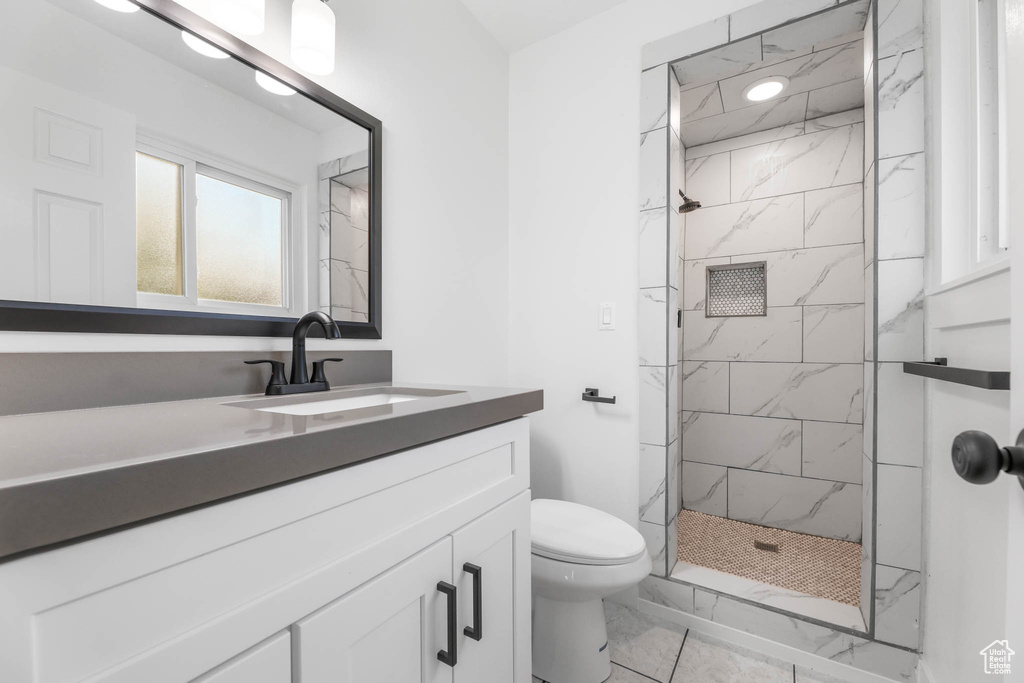 Full bathroom featuring marble finish floors, a marble finish shower, and vanity