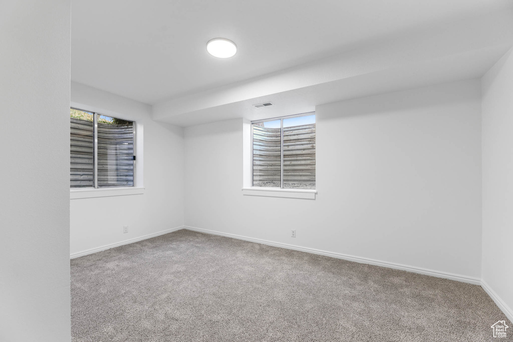 Carpeted empty room with baseboards