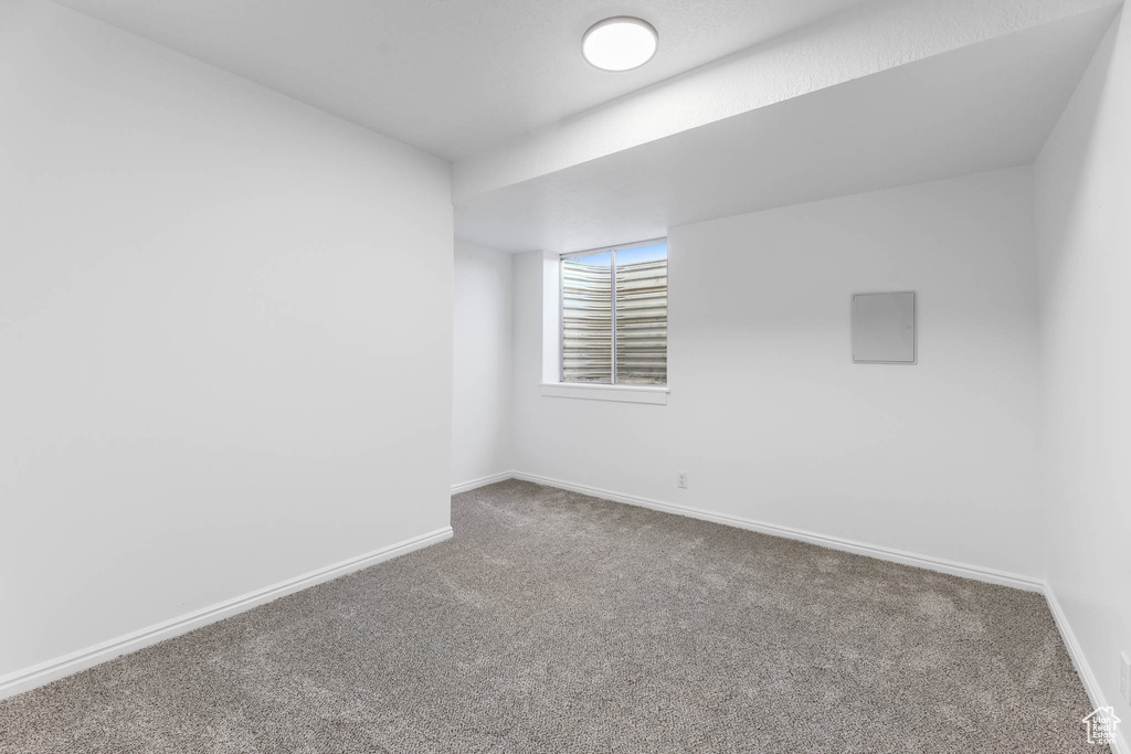 Carpeted empty room featuring baseboards