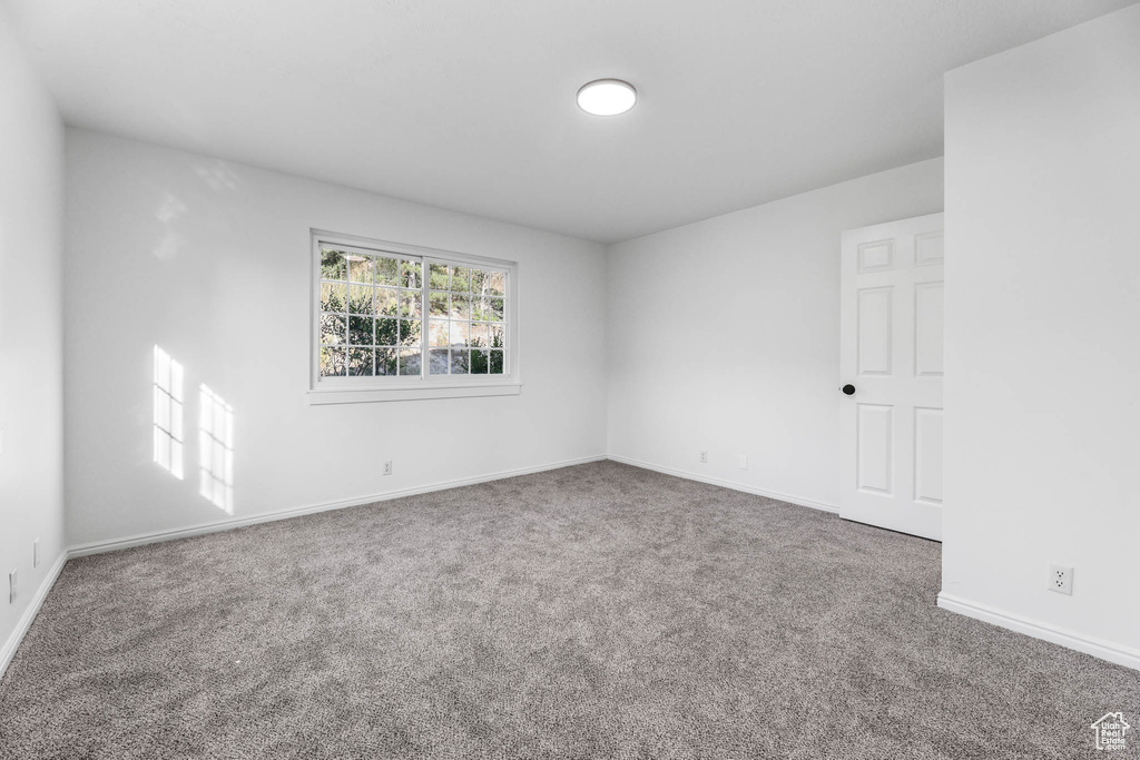 Empty room featuring carpet floors and baseboards