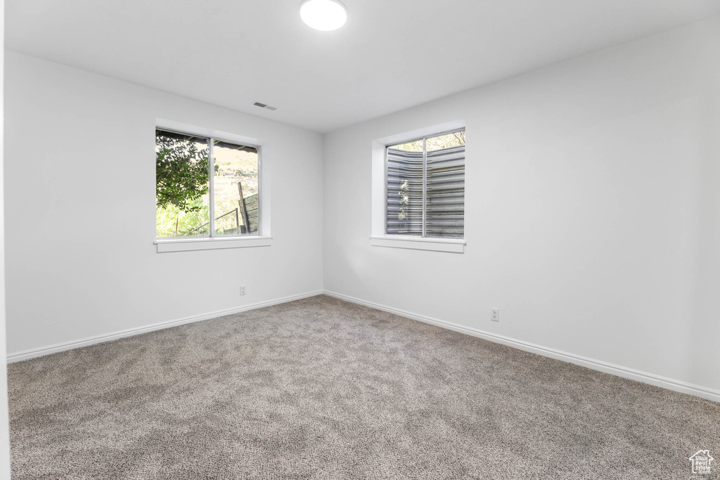 Empty room with carpet and baseboards