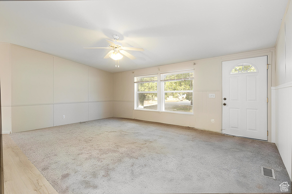Unfurnished living room with ceiling fan and carpet floors