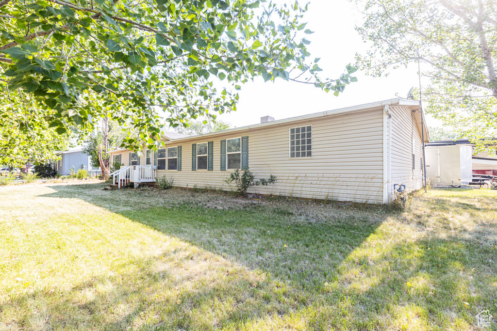 Back of property with a yard and a storage unit