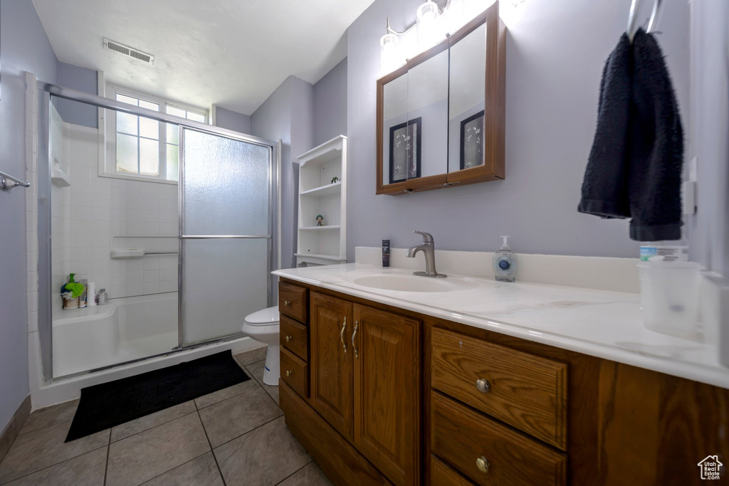 Full bathroom featuring vanity, a shower stall, and tile patterned flooring
