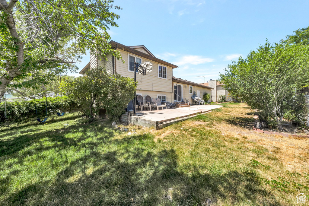 Back of house featuring a lawn and a patio area