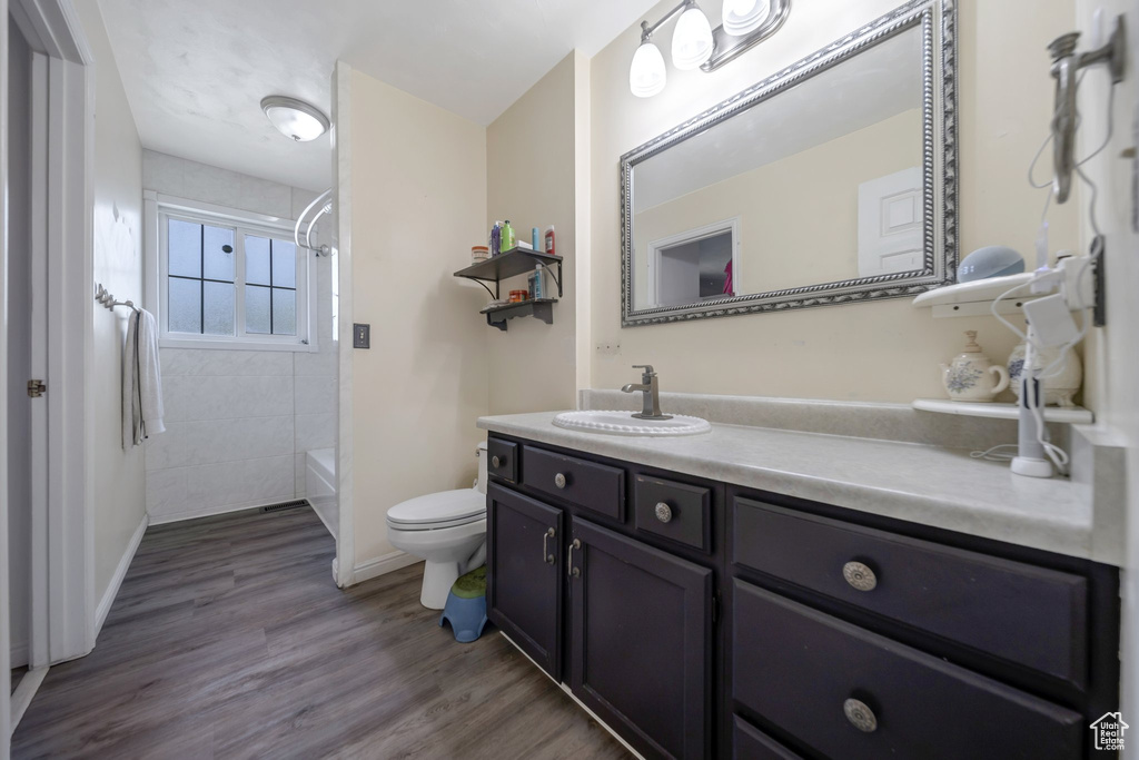 Bathroom with vanity, bathing tub / shower combination, and wood finished floors