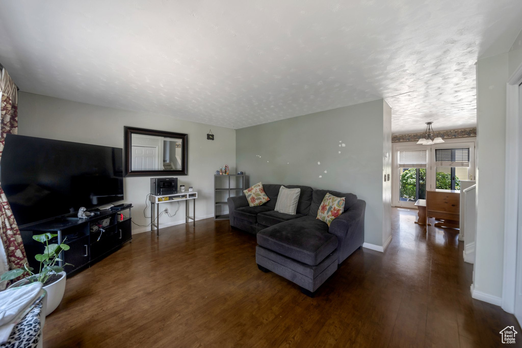 Living area featuring wood finished floors, a textured ceiling, and a chandelier