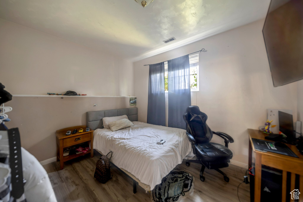 Bedroom with wood finished floors and baseboards