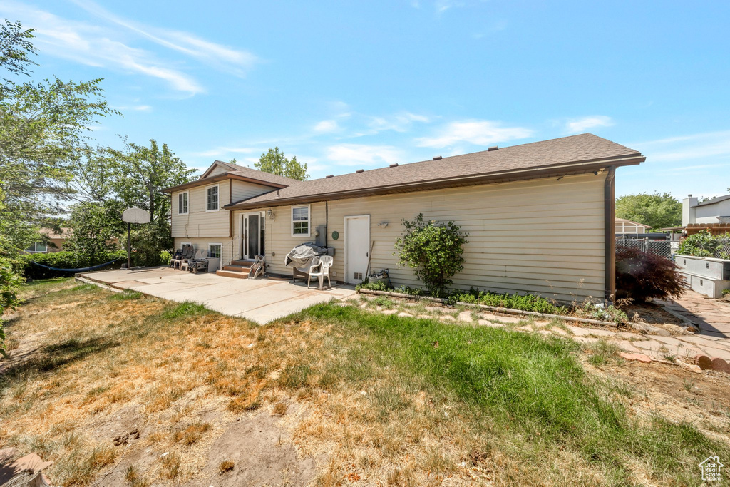 Rear view of property with a patio area, entry steps, and a yard