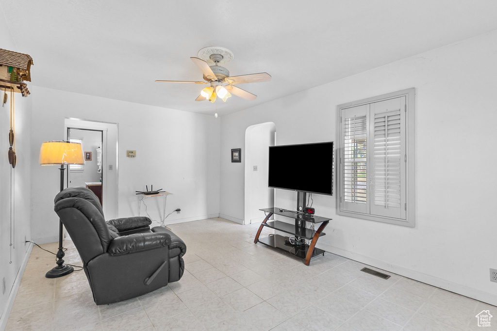 Living area featuring a ceiling fan and baseboards