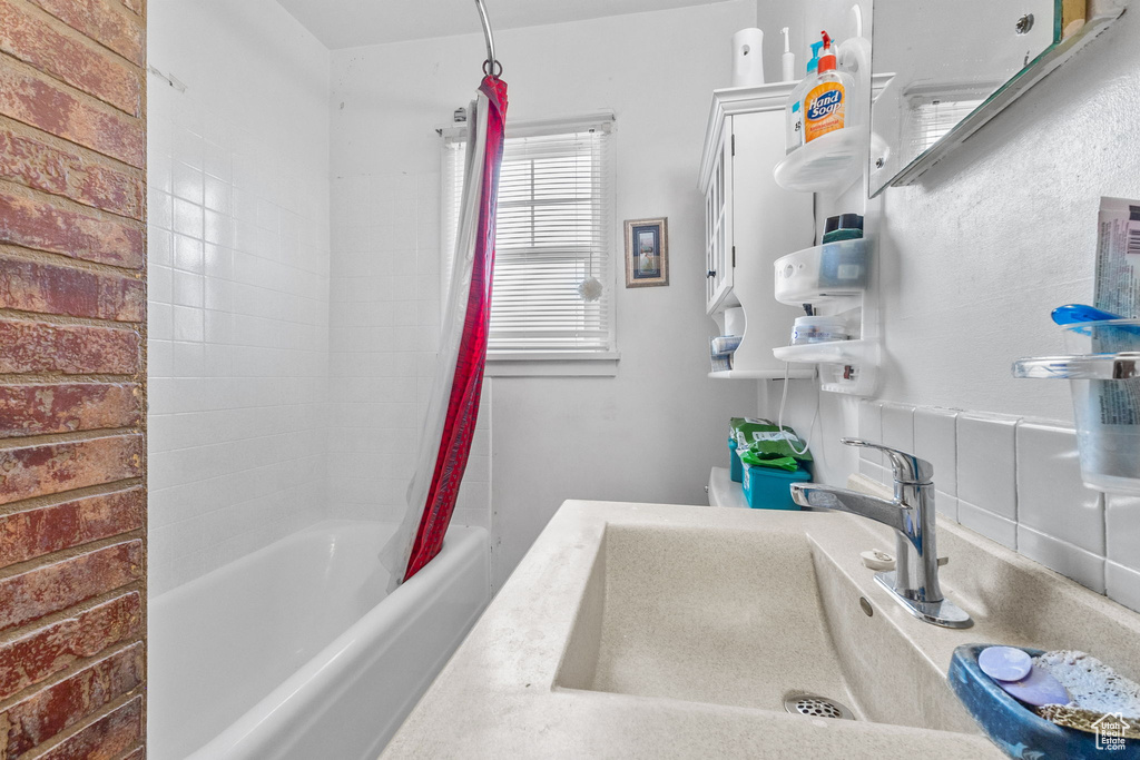 Full bath with a sink and shower / tub combo with curtain