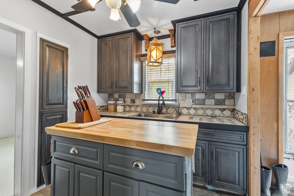 Kitchen featuring wooden counters, ceiling fan, and decorative backsplash