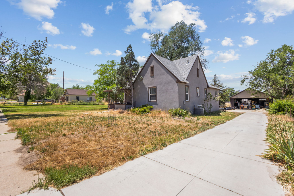 View of side of property with stucco siding and a cooling unit