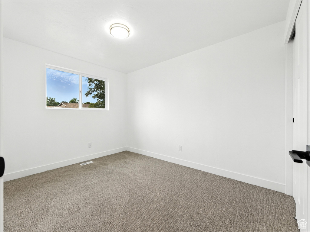 Carpeted spare room with baseboards