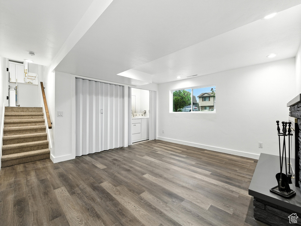 Unfurnished living room with dark wood-style flooring, stairway, and recessed lighting