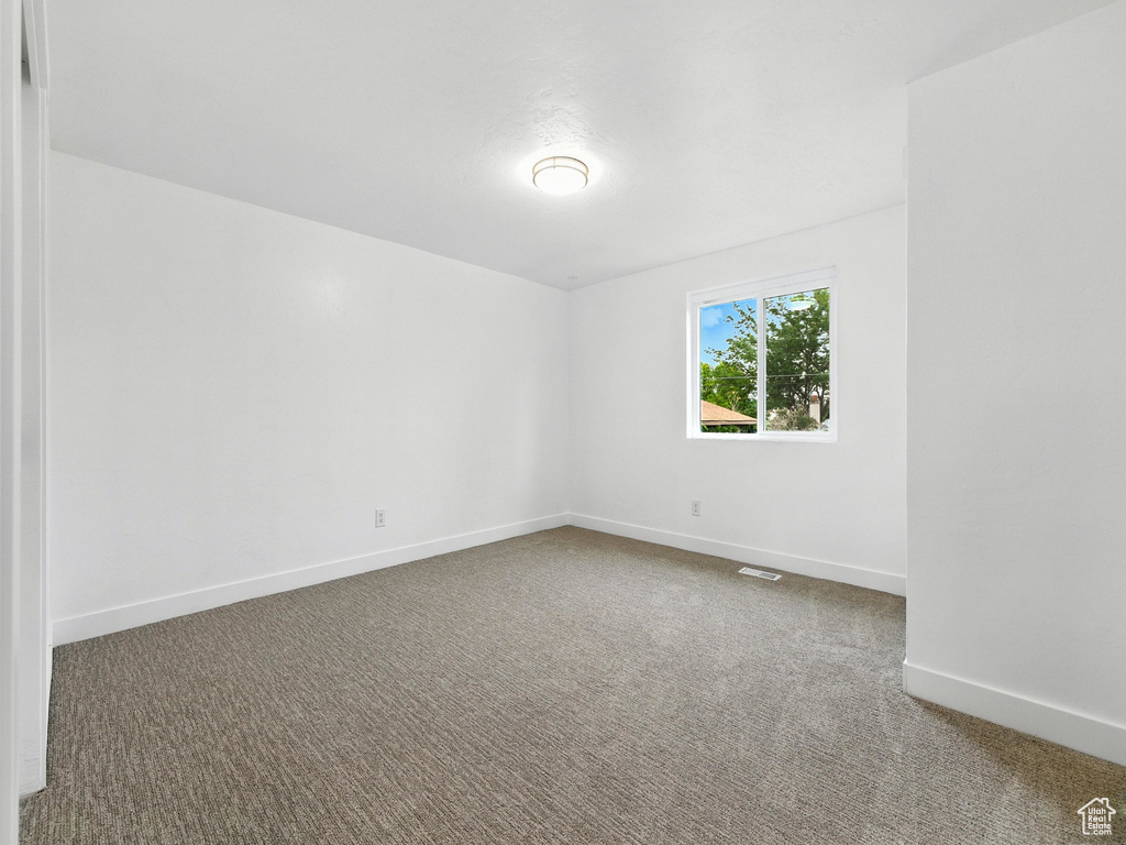 Carpeted empty room with baseboards