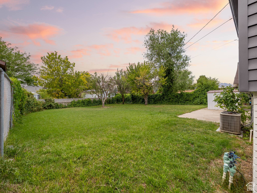 Yard at dusk with a fenced backyard and a patio area