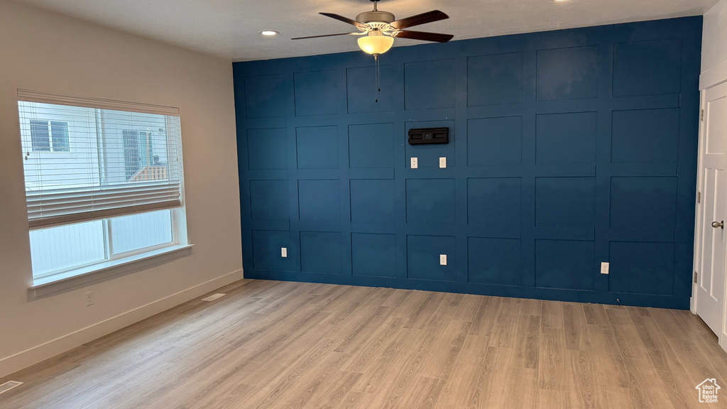 Empty room with a ceiling fan, light wood-style floors, and recessed lighting