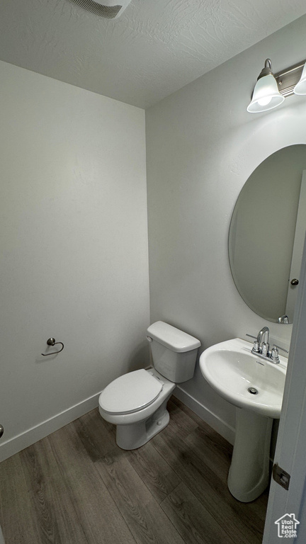Bathroom with wood finished floors and a textured ceiling
