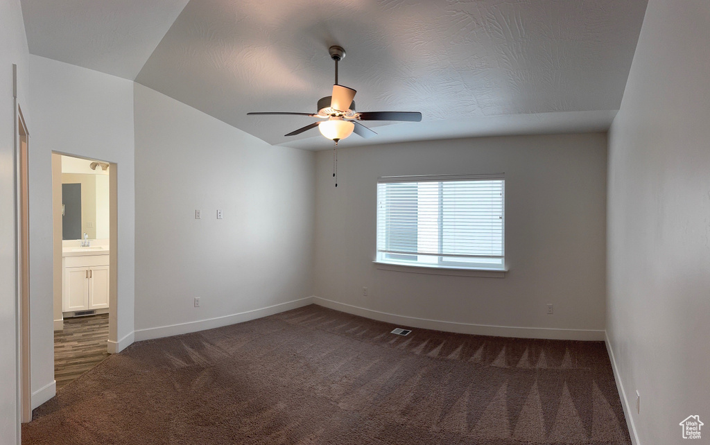 Carpeted empty room with a sink and a ceiling fan