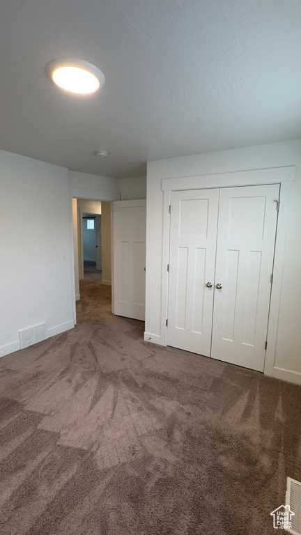Unfurnished bedroom featuring carpet floors and a closet