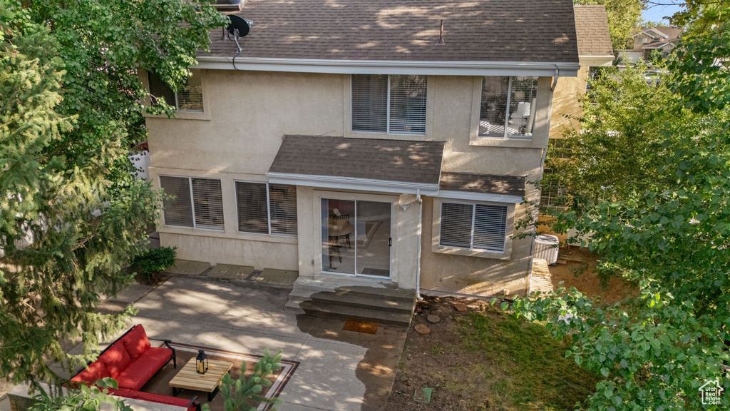 Back of house with stucco siding, roof with shingles, and a patio