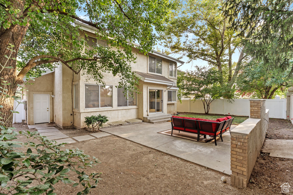 Rear view of property with stucco siding, a patio, entry steps, and an outdoor hangout area