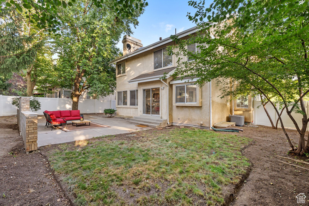 Rear view of house featuring an outdoor hangout area, a patio area, a fenced backyard, stucco siding, and a chimney