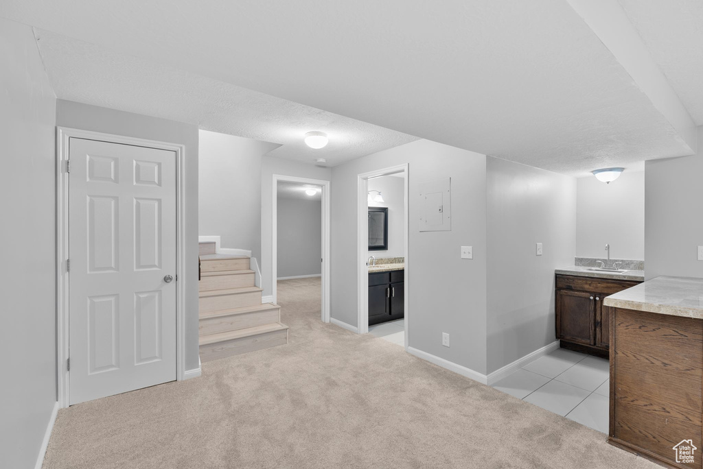 Hallway with stairway and light colored carpet
