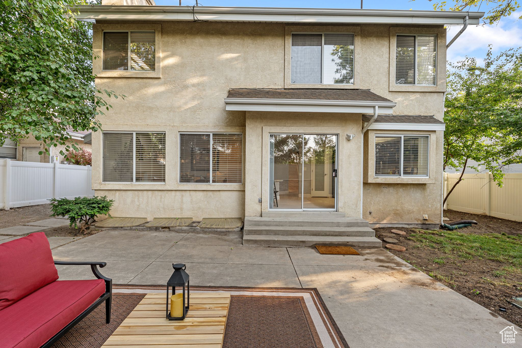 Back of house with stucco siding, a fenced backyard, a patio, and entry steps