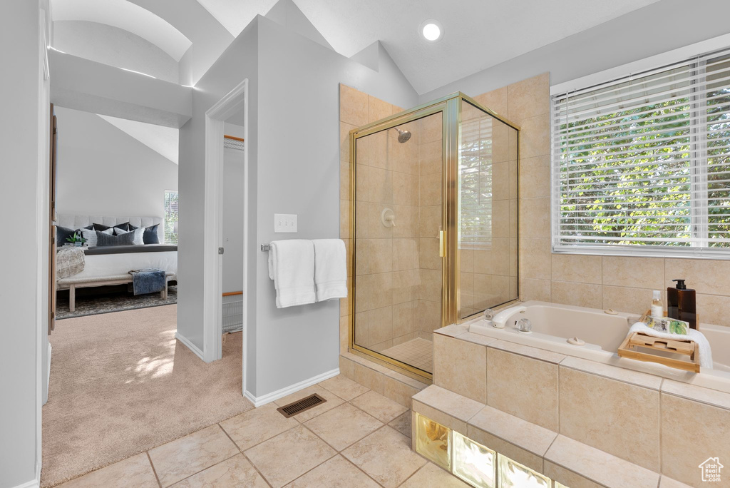 Ensuite bathroom with lofted ceiling, a garden tub, a stall shower, and tile patterned flooring