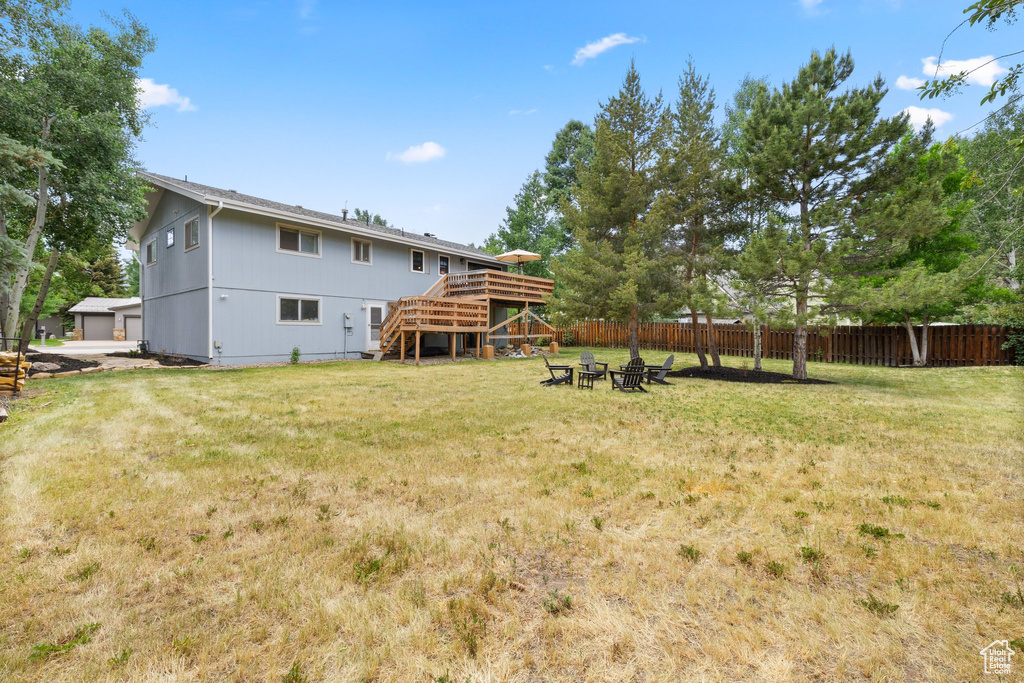 Rear view of property with stairs, a fire pit, and a wooden deck