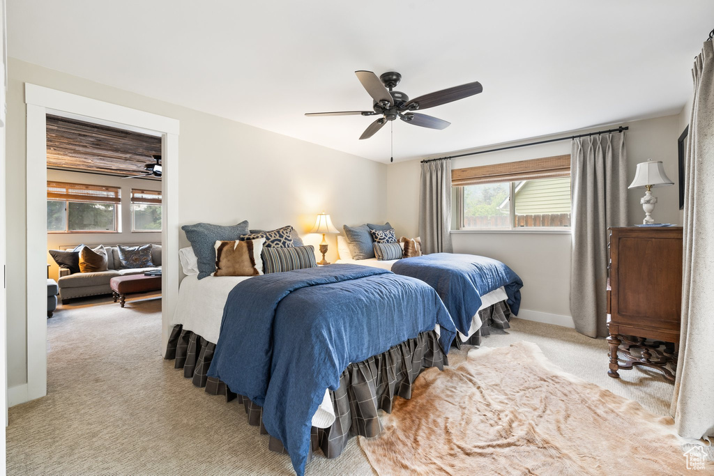 Bedroom featuring light carpet, multiple windows, and a ceiling fan